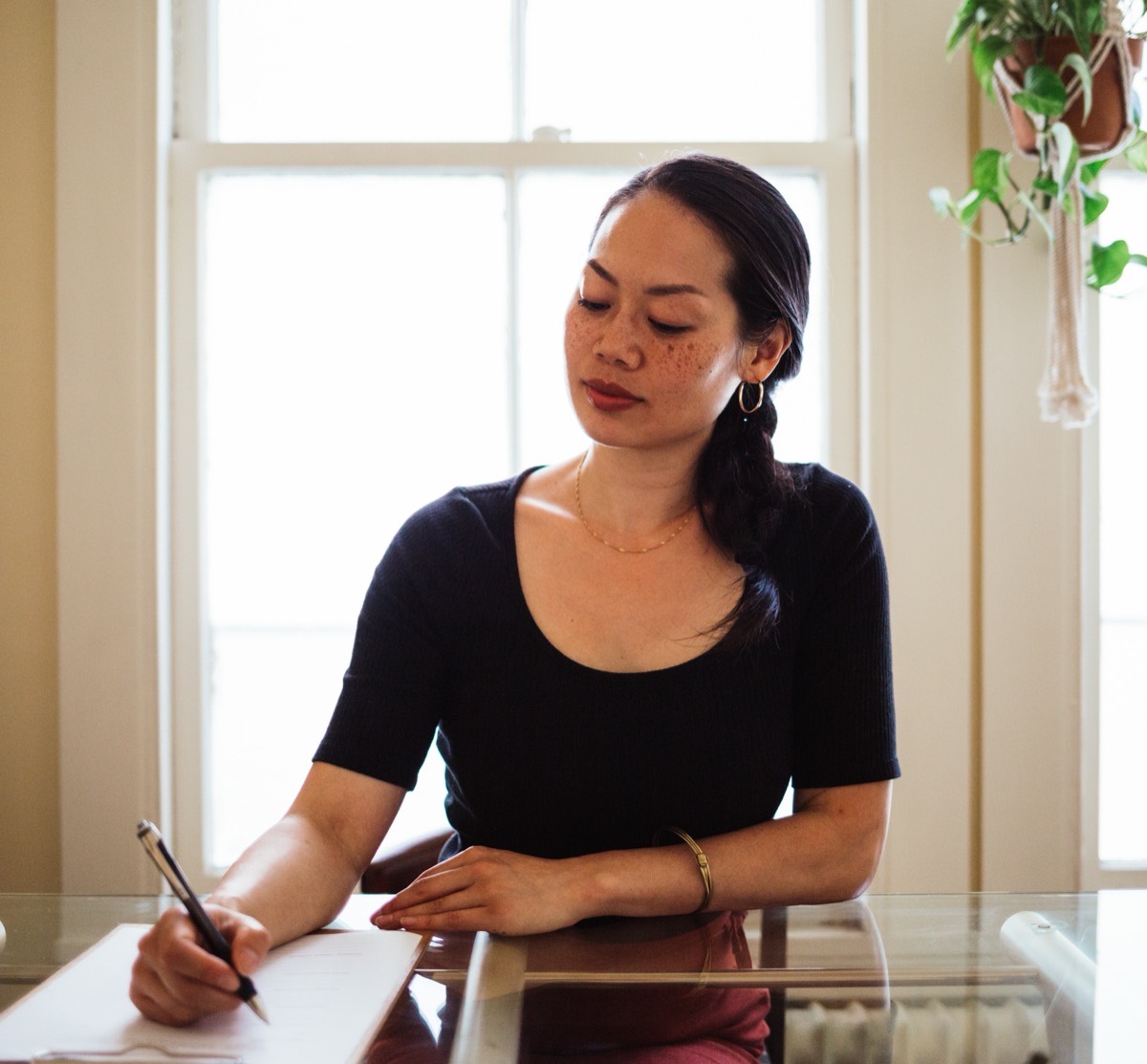 The owner of Luminae Wellness planning at her desk beside a sunlit window