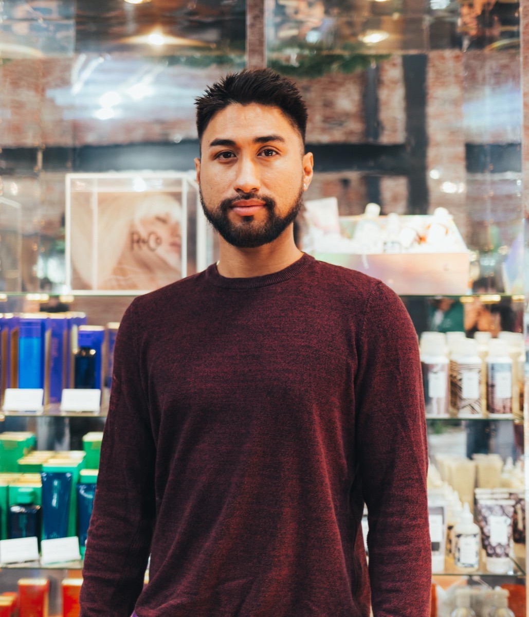 The owner of Taylor Monroe standing in front of the product shelves in his shop